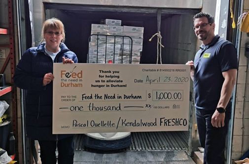 community_cheque Freshco employee holding $1000 cheque for Feed the Need in Durham